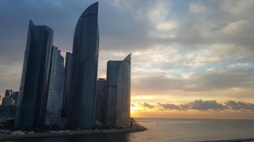a group of tall buildings next to the ocean at Haeundae Mipo House22 in Busan