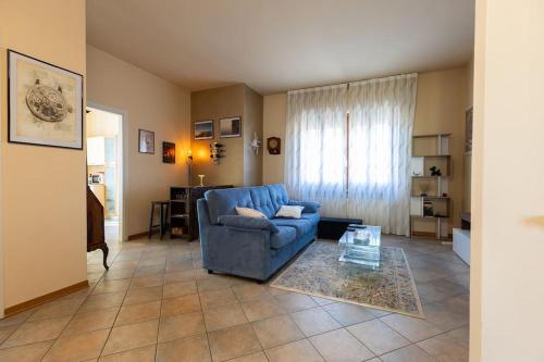 a living room with a blue couch and a table at Casa Gozza in Verzuolo