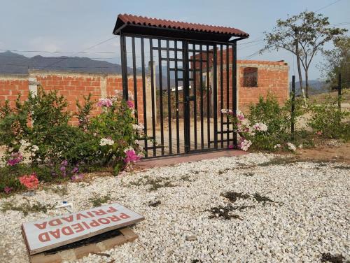 a gate in a yard with a sign in front at Charming Village, Tiny House in Santa Marta