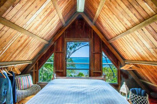 a bedroom with a large bed in a wooden ceiling at The Gallery - Beach hideaway in stunning 1770 in Seventeen Seventy