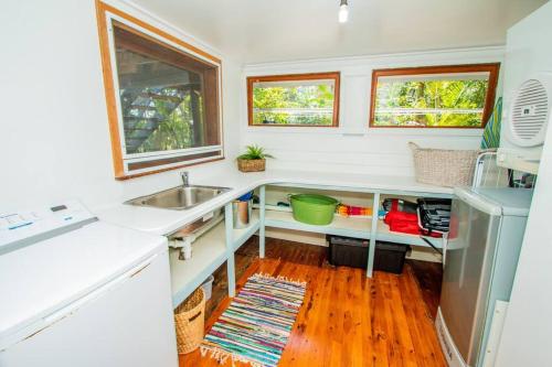 a kitchen with white counters and a sink at The Gallery - Beach hideaway in stunning 1770 in Seventeen Seventy