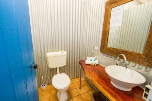a bathroom with a sink and a toilet and a mirror at Sunset Villa - Pet-friendly cottage in 1770 in Seventeen Seventy