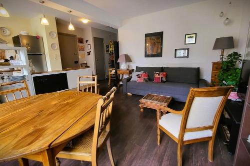 Appartement des beaux-arts في بيزنسون: غرفة معيشة مع طاولة خشبية وأريكة
