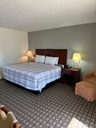 a hotel room with a bed and a chair at Budget Inn Motel in Storm Lake