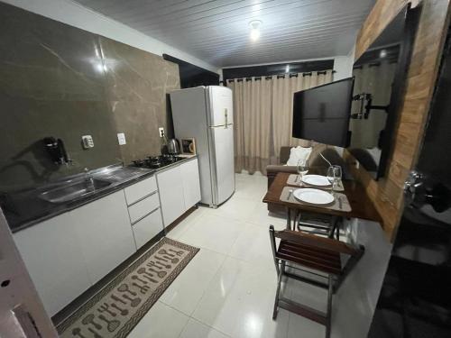a small kitchen with a table and a refrigerator at Apartamento Mobiliado centro de Palmas in Palmas