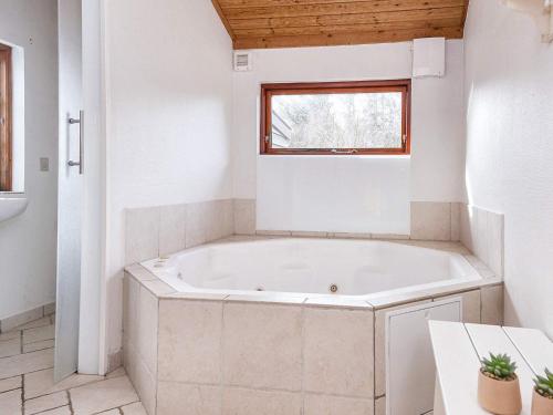 a white bath tub in a bathroom with a window at 8 person holiday home in Ringk bing in Ringkøbing