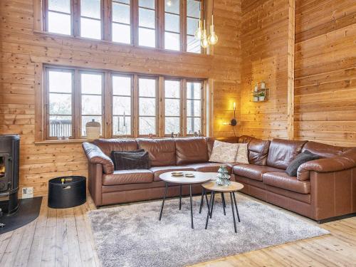 a living room with a brown leather couch and a table at 8 person holiday home in Ringk bing in Ringkøbing