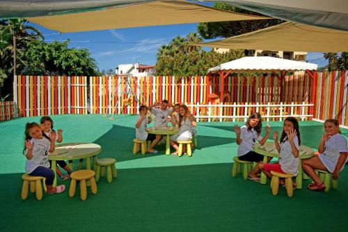 a group of children sitting at tables in a playground at Le Canne Family Resort & Spa in Ischia