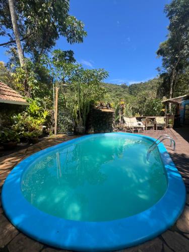 a blue swimming pool with a view of the mountains at Pousada Lua Bonita in Nova Lima