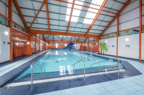een groot binnenzwembad met een groot zwembad bij CaSa VistA - Holiday Home On The Beach in Clacton-on-Sea