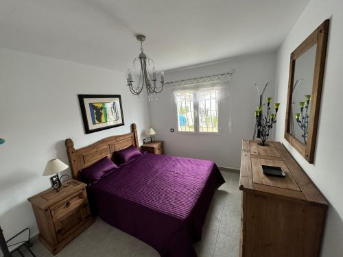 una camera con letto viola e tavolo di Casa Tossal Gros, near Oliva, Spain a La Font D´En Carròs