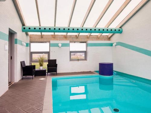 a swimming pool in a room with a ceiling at 8 person holiday home in Knebel in Knebel