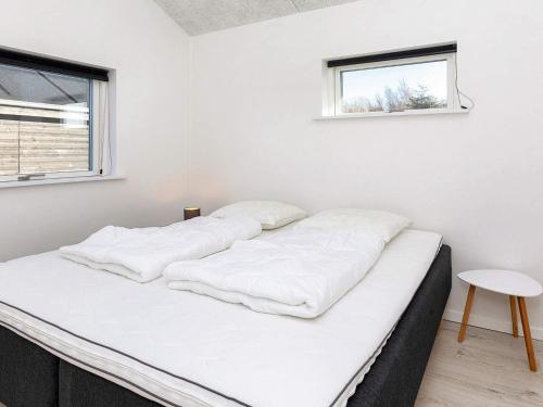 two beds in a white room with a window at Modern Cottage with Spa - By Traum Ferienwohnungen in Vinderup