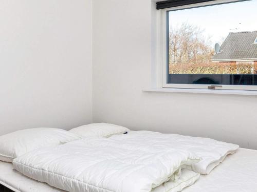 a white bed in a room with a window at Modern Cottage with Spa - By Traum Ferienwohnungen in Vinderup