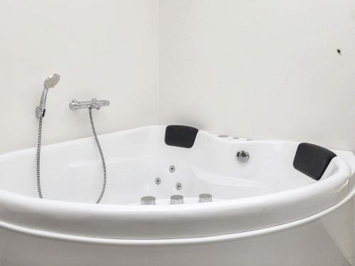 a white bath tub in a white bathroom at Modern Cottage with Spa - By Traum Ferienwohnungen in Vinderup