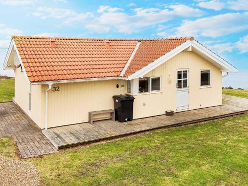 een klein wit huis met een grote achtertuin bij 4 person holiday home in Vinderup in Vinderup