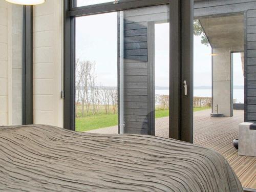 1 dormitorio con ventanas grandes y vistas al océano en Holiday home Frederiksværk X, en Frederiksværk