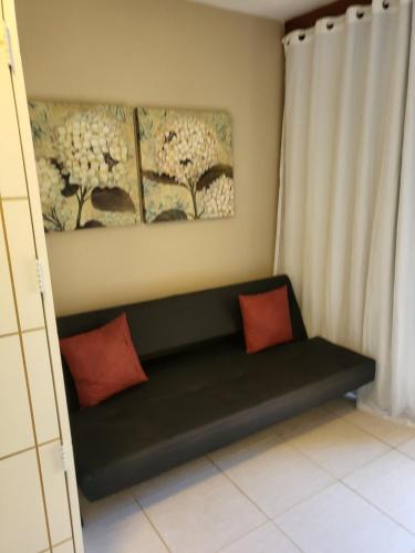 a green bench with two red pillows in a room at Gravatá Winterville Residence in Gravatá