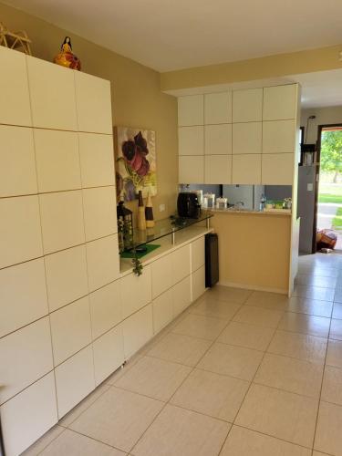 a kitchen with white cabinets and a tiled floor at Gravatá Winterville Residence in Gravatá
