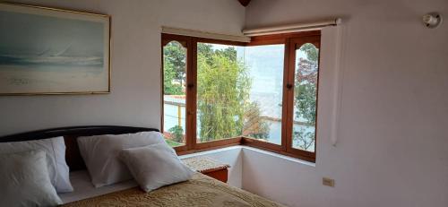 a bedroom with a bed and a large window at Hotel Villa Paz in Villa de Leyva