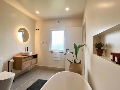 uma casa de banho com um WC, um lavatório e uma janela em Sunday Morning Guesthouse em Aljezur