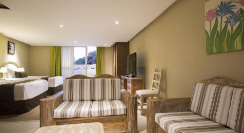 a hotel room with a bed and a living room at Gamma Cuernavaca Puerta Paraiso in Cuernavaca