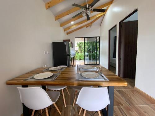 a kitchen with a large wooden table with white chairs at Villa Sueños del Arenal in Fortuna