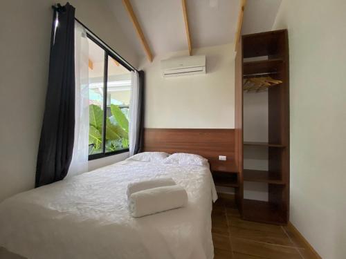 a bedroom with a white bed and a window at Villa Sueños del Arenal in Fortuna