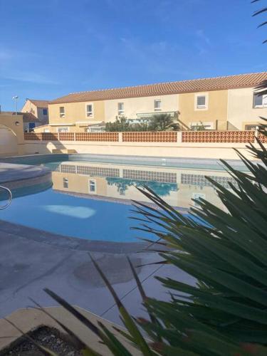 a large swimming pool in front of a building at Tropical Duplex : Bord de mer + Piscine in Frontignan