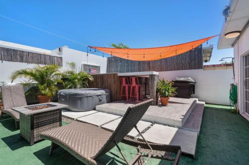 a patio with chairs and a table and a grill at Pool House by Isla Verde Beach home in San Juan