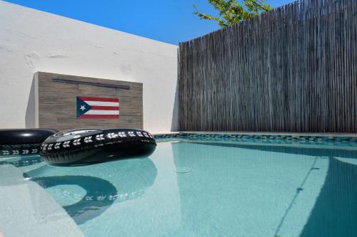a swimming pool with two tires sitting next to a fence at Pool House by Isla Verde Beach home in San Juan