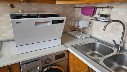 a kitchen with a sink and a washing machine at Parkview Family Apart in Baku