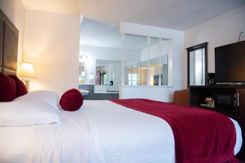 Un dormitorio con una gran cama blanca con una manta roja. en Cottonwood Inn, en Salem