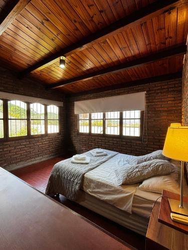 a bedroom with a large bed in a brick wall at Casa 'Los Colibries' in Salta