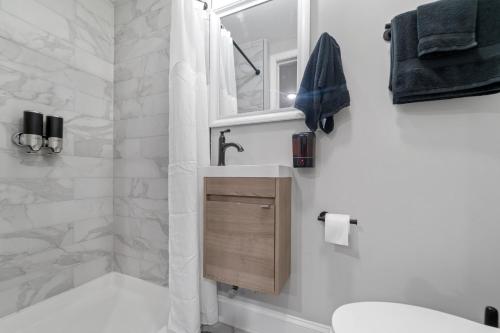 ein Badezimmer mit einem Waschbecken, einem WC und einem Spiegel in der Unterkunft Midcentury Guest Suite w/ King Size Bed in Baltimore