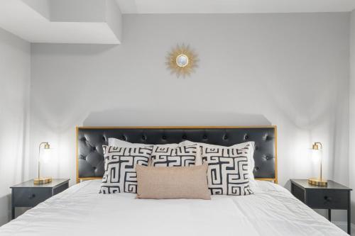 ein weißes Schlafzimmer mit einem großen Bett mit zwei Nachttischen in der Unterkunft Midcentury Guest Suite w/ King Size Bed in Baltimore