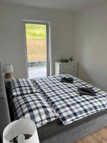 um quarto com uma cama com um cobertor xadrez em Apartmánový dom Panoráma Park Vlková 