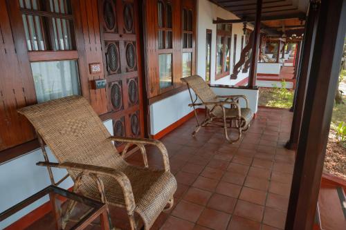 two chairs on the porch of a house at Coconut Lagoon Kumarakom - A CGH Earth Experience in Kumarakom