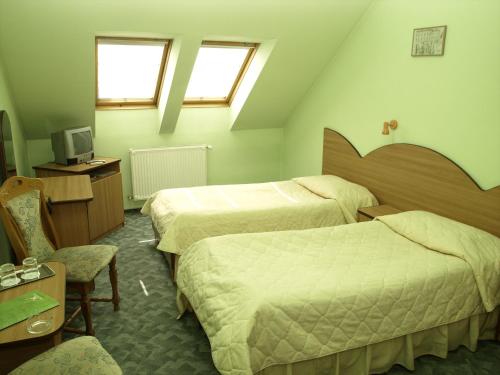 a hotel room with two beds and a tv at Hotel Everest in Târgu-Mureş