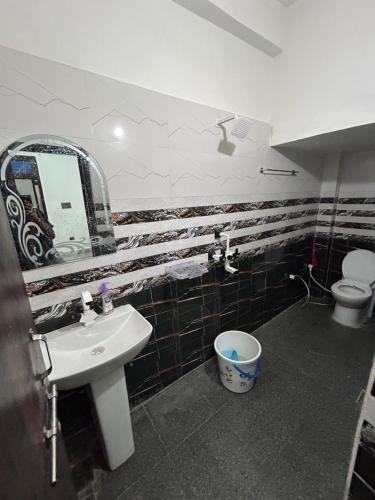 a bathroom with a sink and a mirror and a toilet at Entire family vacation home in Vrindāvan