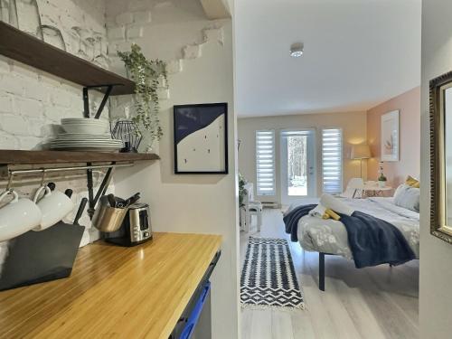 a bedroom with a bed and a table in a room at The Sunny Paradise in Mont-Tremblant