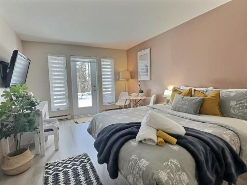 sypialnia z 2 łóżkami i oknami z okiennicami w obiekcie The Sunny Paradise w mieście Mont-Tremblant