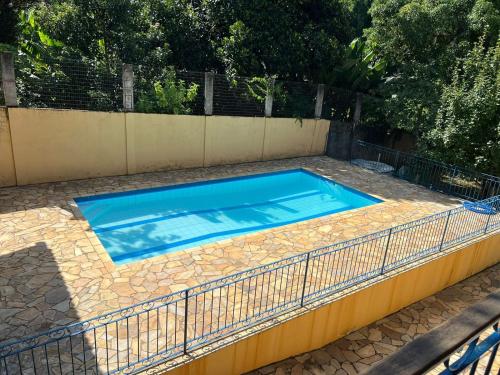 a large blue swimming pool with a fence around it at Pousada dos Girassóis in Conservatória