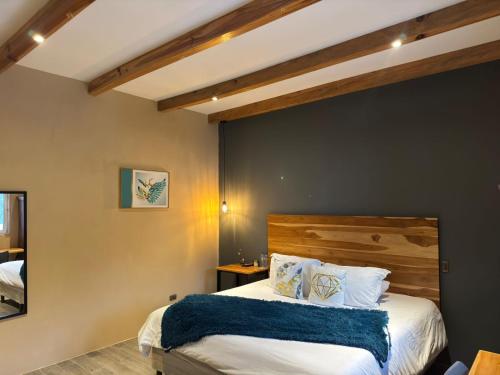 una camera con un grande letto con testiera in legno di Casa Montana Hotel a Chichicastenango