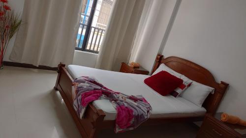 een slaapkamer met een bed met een rood kussen bij Apartamento central - Villa Xiomara in Santa Rosa de Cabal