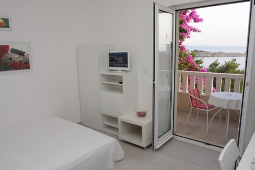 a bedroom with a bed and a balcony with a table at Apartments Villa Desire in Makarska