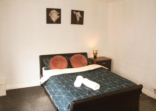 a bedroom with a bed with two towels on it at AmazenHome - Stylish 3 bed - House of Ebony in Leigh