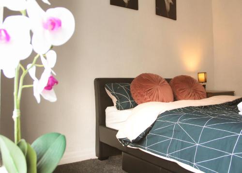 AmazenHome - Stylish 3 bed - House of Ebony في لييغ: غرفة نوم مع سرير مع وسادتين