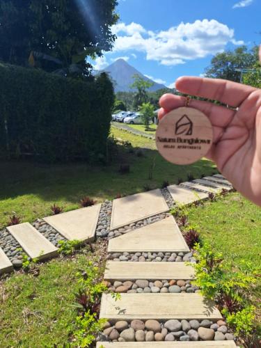 a person holding up a stone walkway at Natura Bungalows in Fortuna