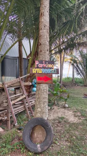 a sign on a tree with a tire next to it at BanrabianglayLangsuan room B in Ban Hin Sam Kon